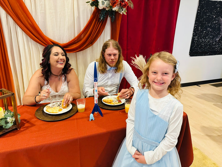 Bride, groom and flower girl at the head table with rocket centerpiece, Observer Ranch Penrose Colorado