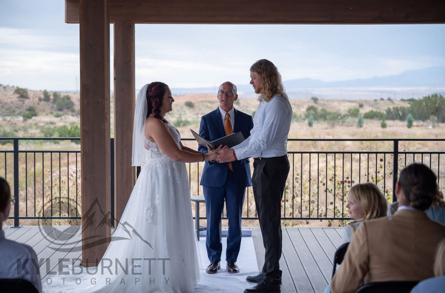 Wedding ceremony on the covered deck with guests and mountains, Observer Ranch Penrose Colorado