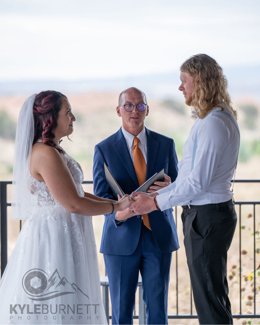 Bride and groom exchange vows with officiant outdoors at Observer Ranch, Penrose Colorado
