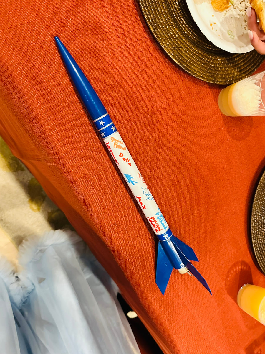 Model rocket centerpiece on an orange tablecloth at a wedding, Observer Ranch Penrose Colorado